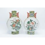 A pair of 20th century oriental moon vases with birds in foliage design (2). Both pieces have damage