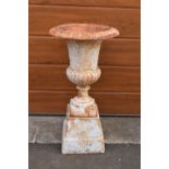 An antique cast iron campagna urn on a matching cast iron base. Approximately 82cm tall.