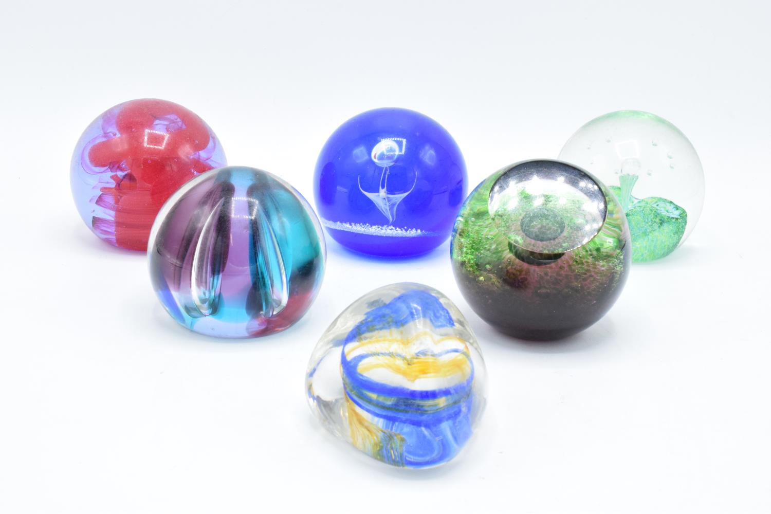 A collection of Caithness glass paperweights to include Pebble, Scimitar, Nebula, Moonlight