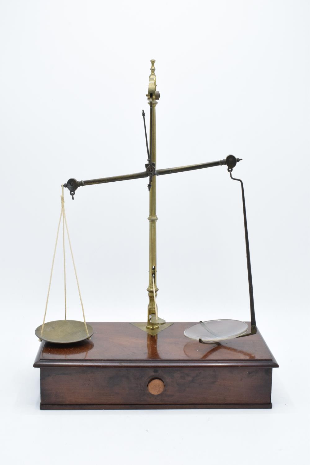 Early 20th century brass scales mounted a wooden base with a pull out. They display well. Might