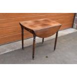 19th century light mahogany Pembroke table on casters with a single draw and a faux drawer at the