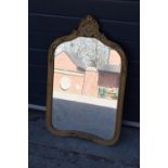 An early 20th century gilt-effect ornate framed mirror. 83cm tall. A crack to the top ornate