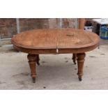 Large Victorian extending dining table on carved legs with an extra leaf and the handle. In good