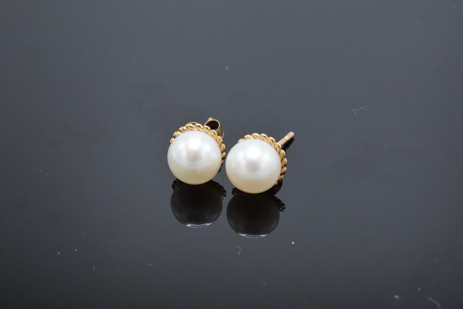 A pair of 9ct gold earrings with pearls. Gross weight 1.2 grams. Unmarked but test as 9ct.