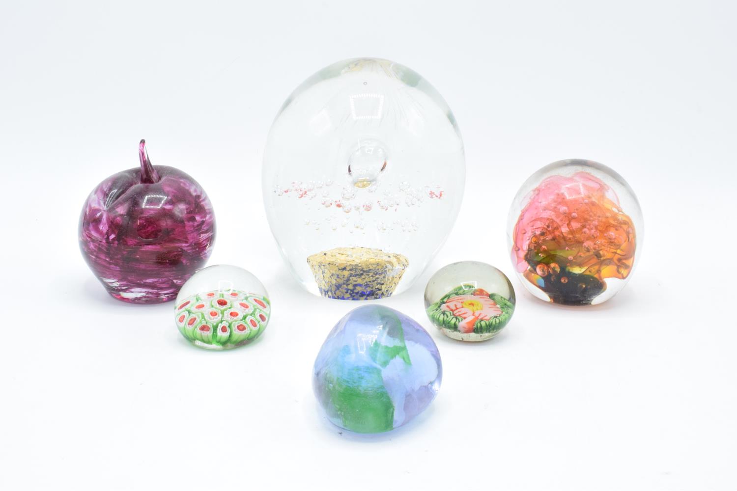 A good collection of glass paperweights to include an apple by Kerry Glass, a large example and 4