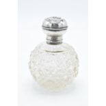 A silver and glass scent bottle with Reynold's Angel on the silver top. With an associated