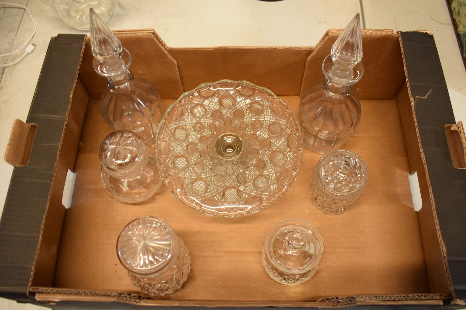 A collection of glass ware to include a pair of decanters, chutney jars, a cake stand etc. In good