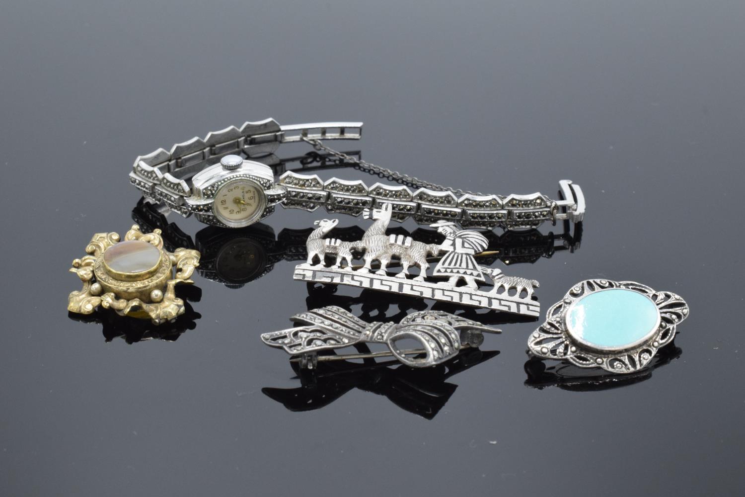 A collection of items to include silver and marcasite brooches, a marcasite wrist watch and a