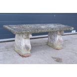 A vintage garden ornament in the form of a bench with supports with grape and vines decoration,