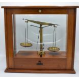 A set of laboratory scales in a wooden case made by Philip Harris and Co Ltd. In good condition.