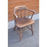 A reproduction wooden captains chair. 76cm tall. In good sturdy condition with some marks, water