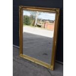 Large 20th century gilt effect wall mirror in ornate wooden frame. 115cm by 91cm. In good condition.