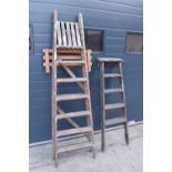 A pair of vintage wooden ladders. Both are rickety and need attention. Signs of old worm. One