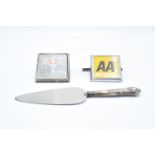 A trio of items to include a silver handled cake slice, a vintage RAC badge and a vintage AA