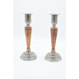 A pair of silver plate and copper candlesticks with a column effect body. 24cm tall.