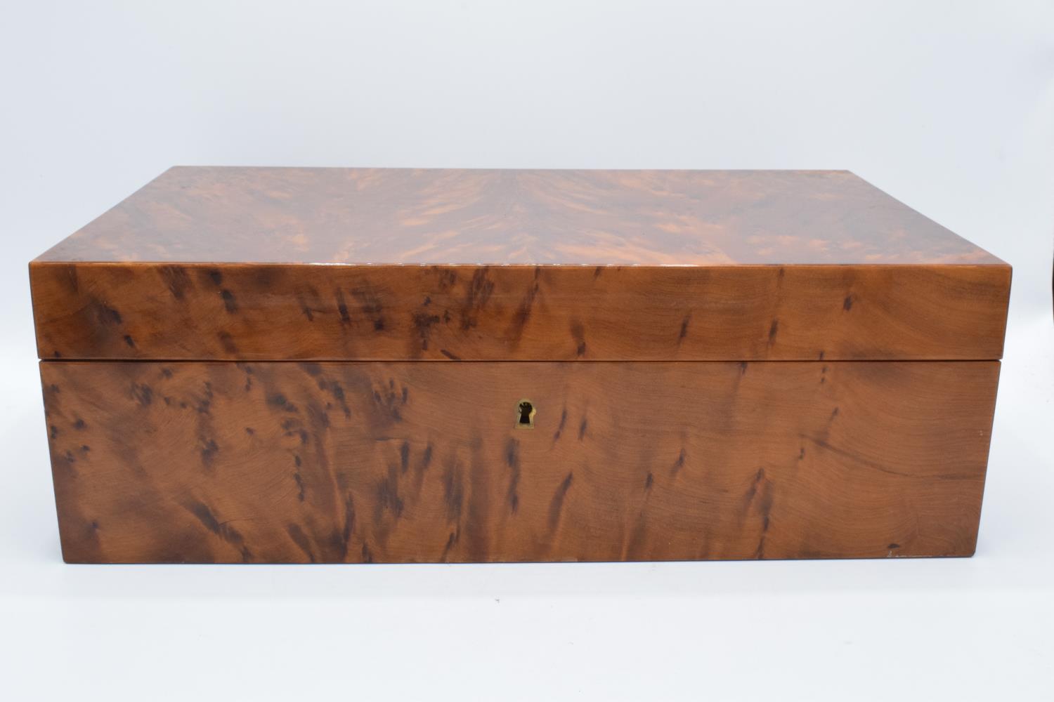 A modern veneered wooden cigar humidor with brass fixtures and fitting with a working lock and