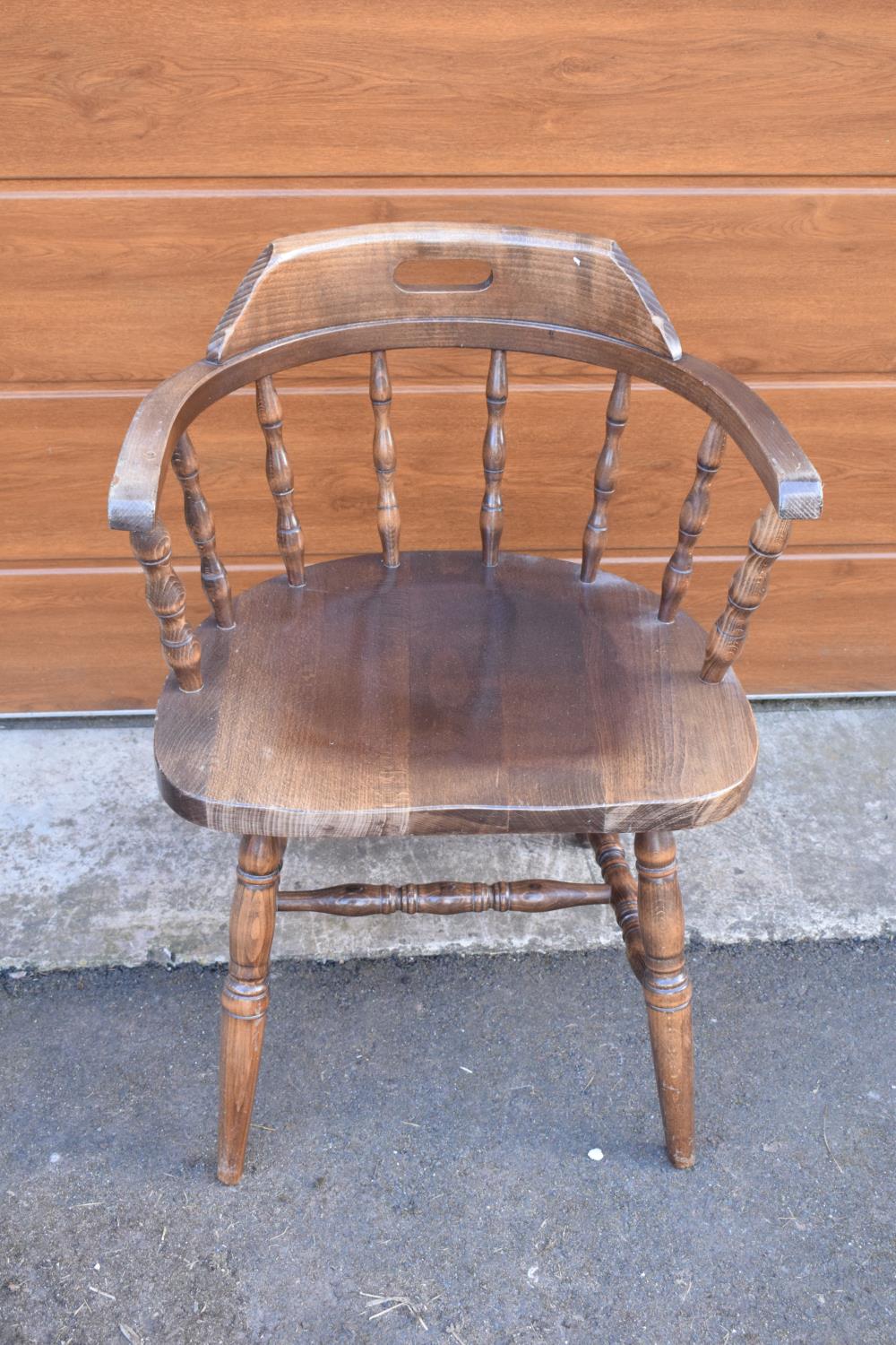 A reproduction wooden captains chair. 76cm tall. In good sturdy condition with some marks, water