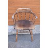 A reproduction wooden captains chair. 76cm tall. In good sturdy condition with some marks, water