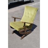 An early to mid 20th century American-style upholstered wooden rocking chair with spring action