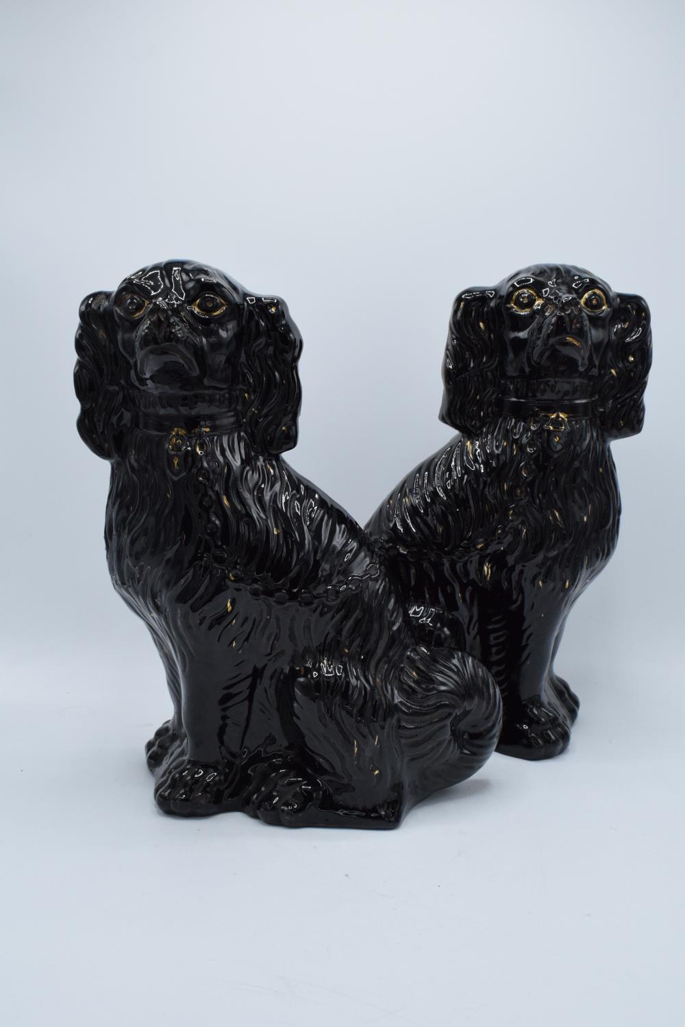 A pair of 20th century large Staffordshire dogs in a black gloss colourway with some gold highlights