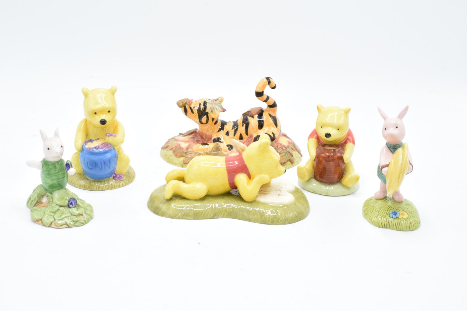 A collection of Royal Doulton Winnie The Pooh figures to include All the flowers are waking up, Love