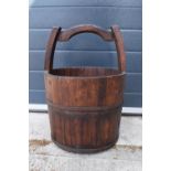 A coopered wooden well bucket with metal bands. 51cm tall. Some age-related wear and tear to include