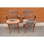 A pair of Edwardian office or captains style chairs with upholstered seats on casters. The