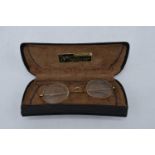 A cased pair of 1/10 10ct gold oval spectacles in original leather carry case by N. J. Rees of 36