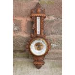 A late Victorian/ Edwardian arts and crafts style carved aneroid barometer. 109cm tall. There are