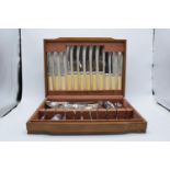 An assorted cutlery canteen with chrome-plated and stainless steel cutlery in a wooden case.