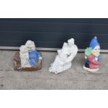 A collection of vintage garden ornaments to include a garden gnome, a figure of a couple and one