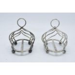 A near pair of silver plated toast racks marked 'Harrods London'. 13cm diameter.