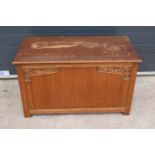 A 1930s wooden blanket box with an ornate carved section. 96 x 50 x 57cm. In good functional