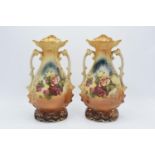 A pair of Edwardian Continental mantle vases decorated with a floral scene with dual handles,