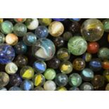 A collection of early to mid 20th century marbles of various sizes to include various designs with