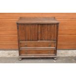 1930s oak Priory style cupboard over 2 draws raised on feet. 99 x 54 x 103.In good functional