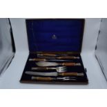 A wooden cased Mappin and Webb horn and silver handled 7-piece carving set with silver banding and