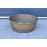 A large oversized antique brass bowl/ basket on a steel base which was used as a log basket/