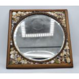 A decorative rectangular mirror with shell encrusted spandrels and circular bevel-edged mirror