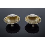 A pair of silver table salts in the form of shells raised on ball feet. Hallmarked for Birmingham