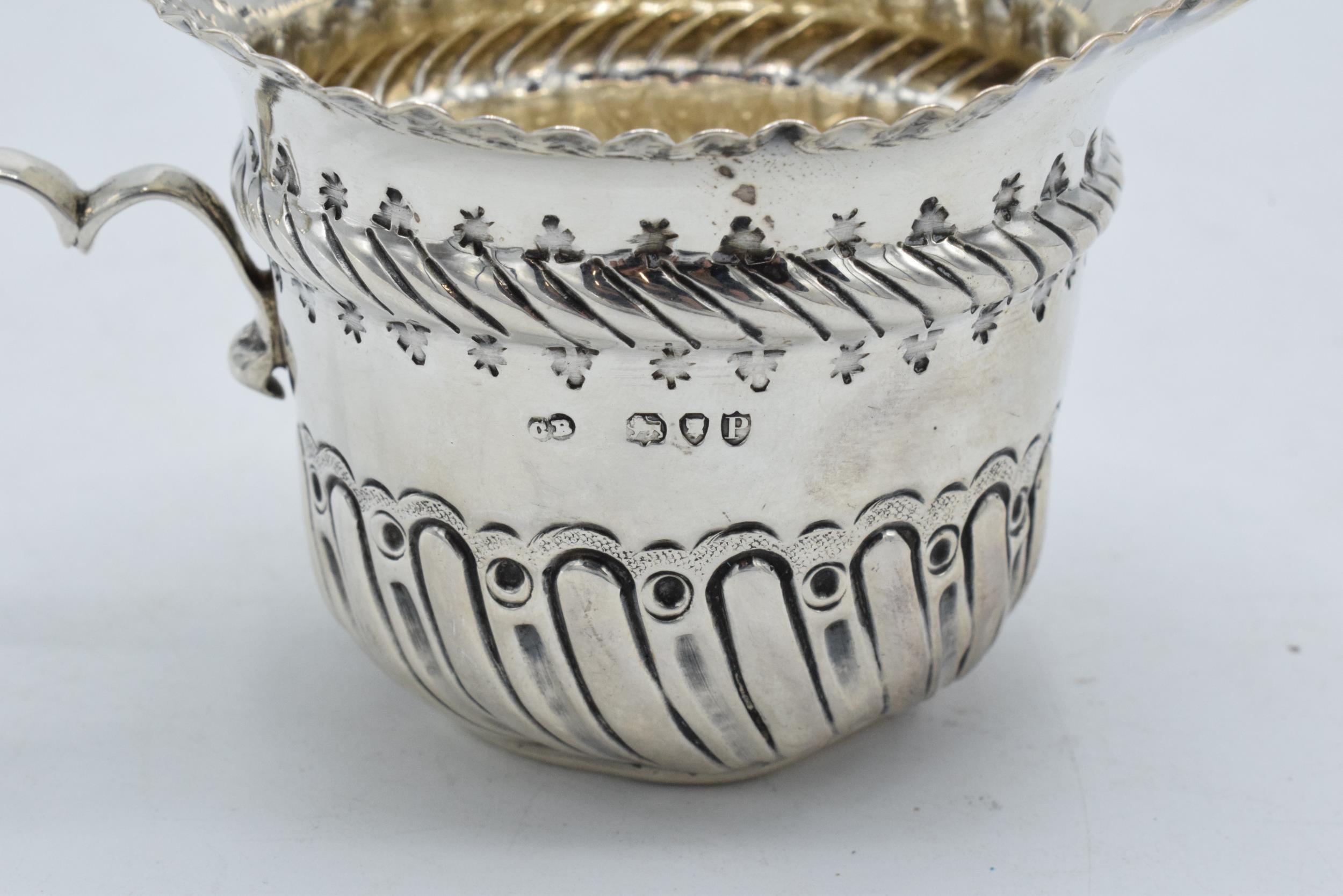 An ornate silver cream jug / sauce jug. London 1890. 53.7 grams. In good condition with some dents - Image 3 of 4
