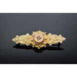 9ct gold ladies sweetheart brooch set with a seed pearl with floral decoration (base metal pin).