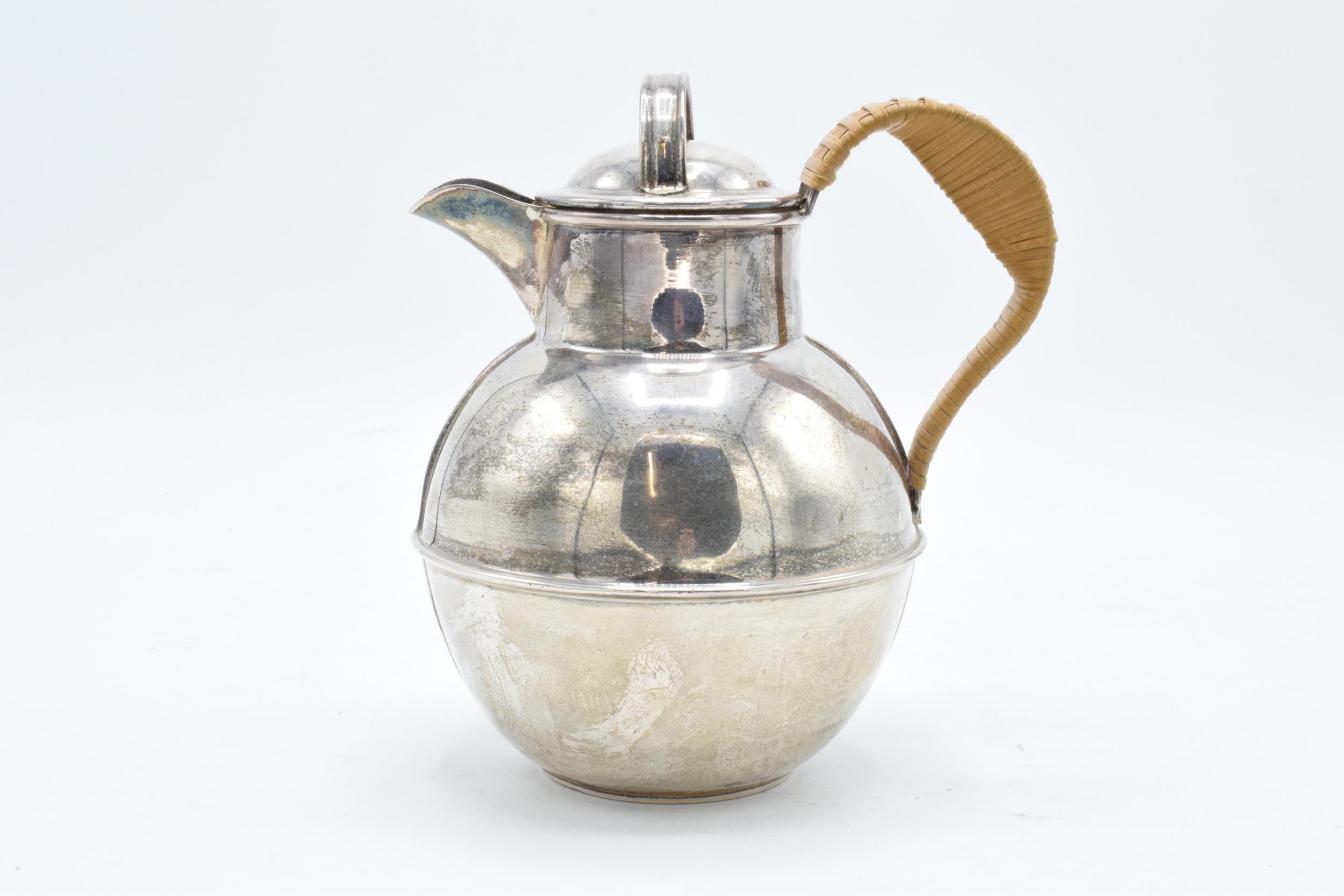 A hallmarked silver Jersey style cream jug with wicker style handle. Gross weight 315.6 grams.