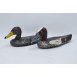 A near pair of of early to mid 20th century decoy ducks, painted palm wood with hard wood heads