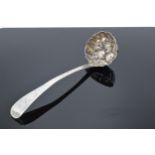 A George III silver sifter ladle embossed with fruit decoration 54.8 grams. Monogram to the top of