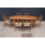 A mid century / retro Gordon Russell extending shaped rectangular dining table together with 6