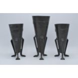 A Knox style pewter vase on three humanistic legs with a companion pair of smaller matching vases (