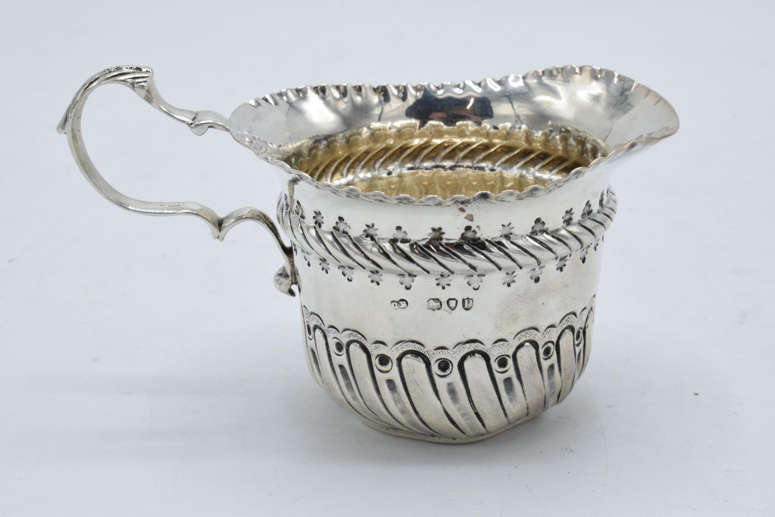 An ornate silver cream jug / sauce jug. London 1890. 53.7 grams. In good condition with some dents - Image 2 of 4