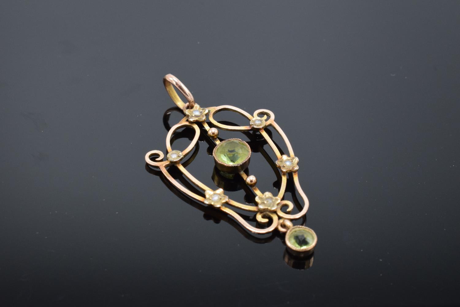 An antique 9ct gold ornate pendant set with peridot and pearls. Gross weight 2.1 grams. Stamp to