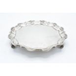 A hallmarked silver salver with shaped edge raised on three feet. Hallmarked for Sheffield 1926.